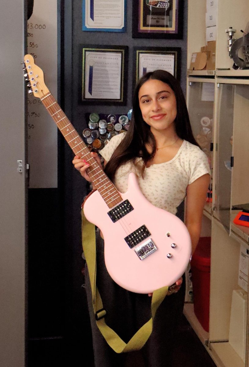 Amina Greene holding her guitar.