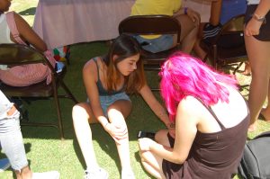 Ramona Jasman-Rios (right), sophomore: I didn’t really want to go to Day on the Green, but I was dragged here by my friends. I’m a good artist and I’m stuck here doing Henna. 