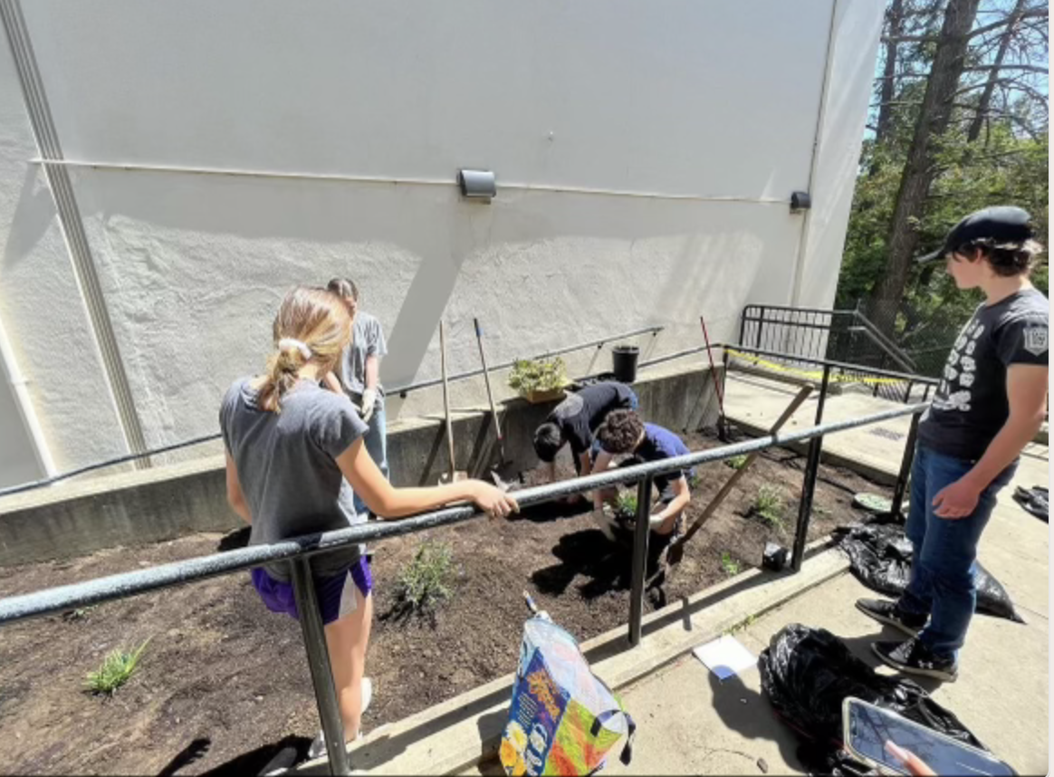 Green Club members set up a planter near the 30s building