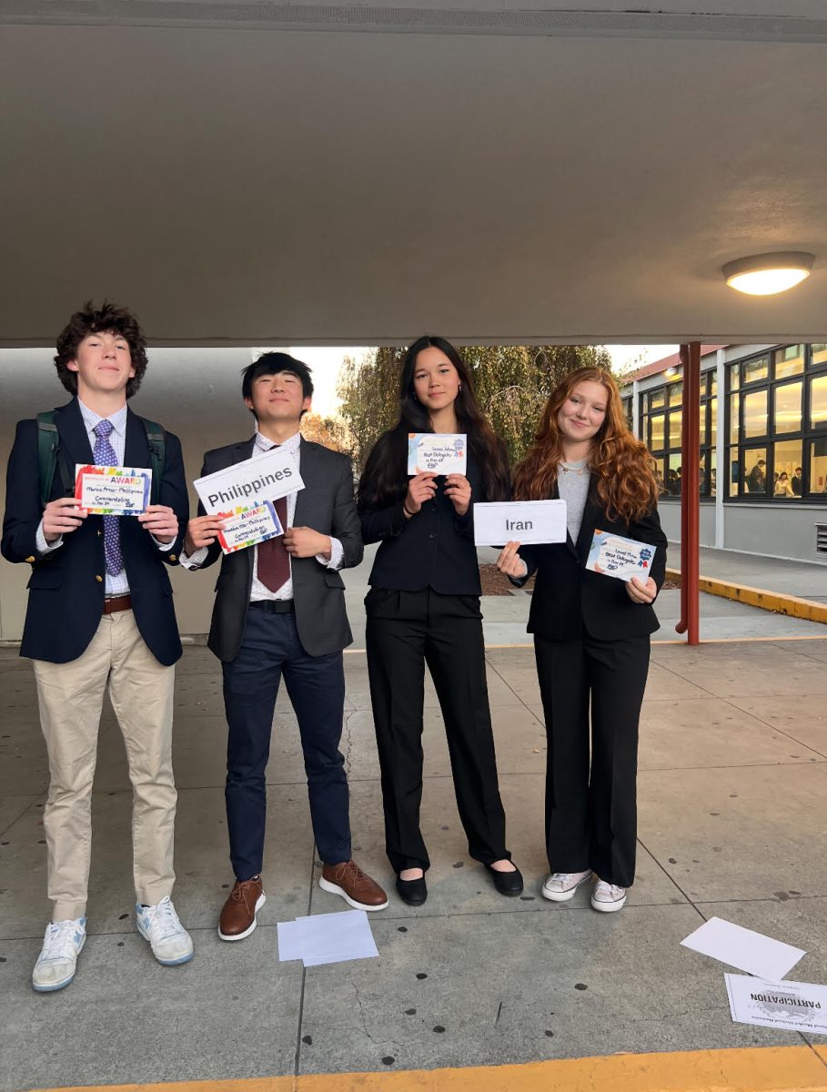 Juniors Marius Arno, Maddox Ma, Geneva Johnson, and Laurel Minor holding their delegate awards.