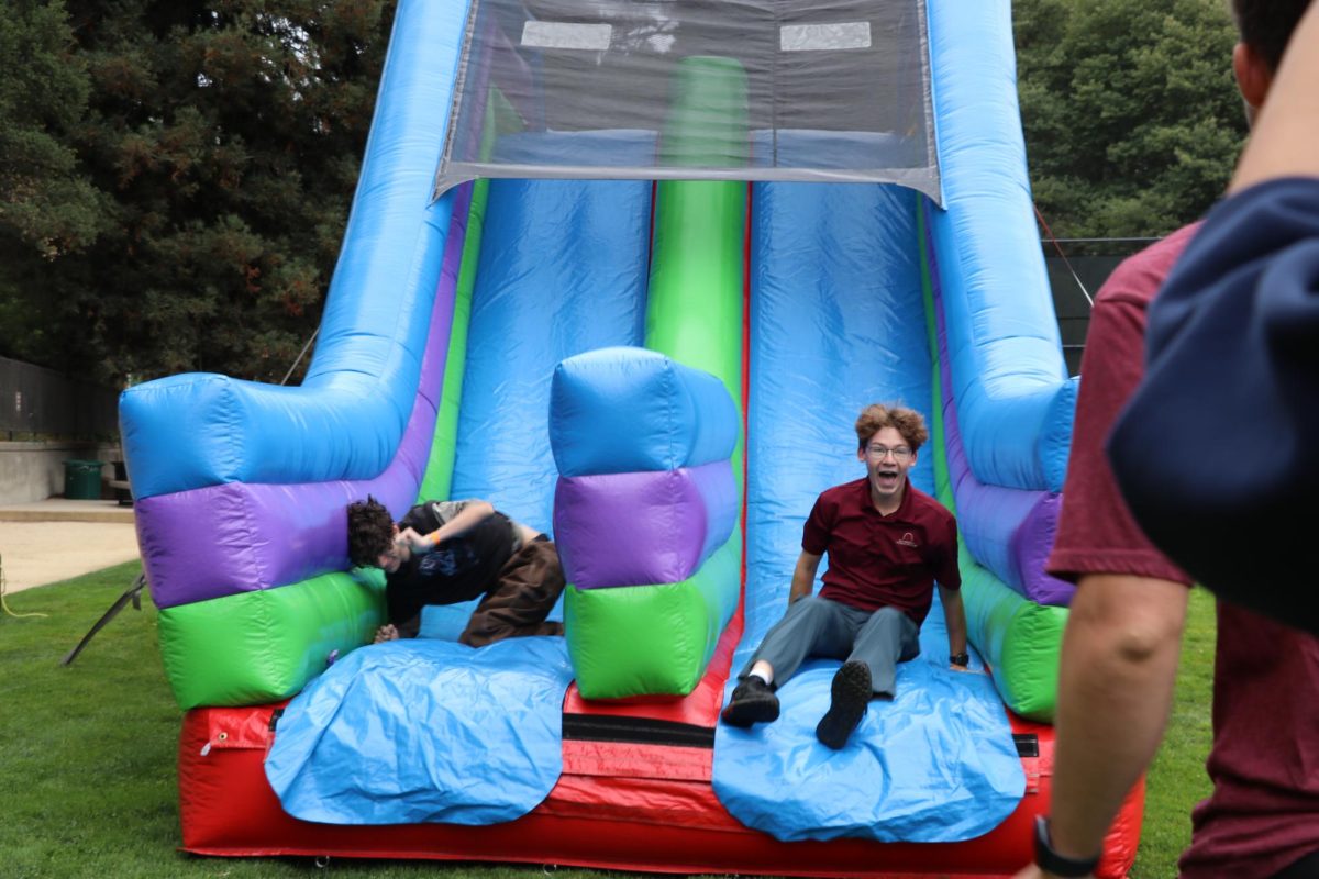 Seniors Rocco Salzer-Garcia and Theo Ferguson race through the inflatable obstacle course.