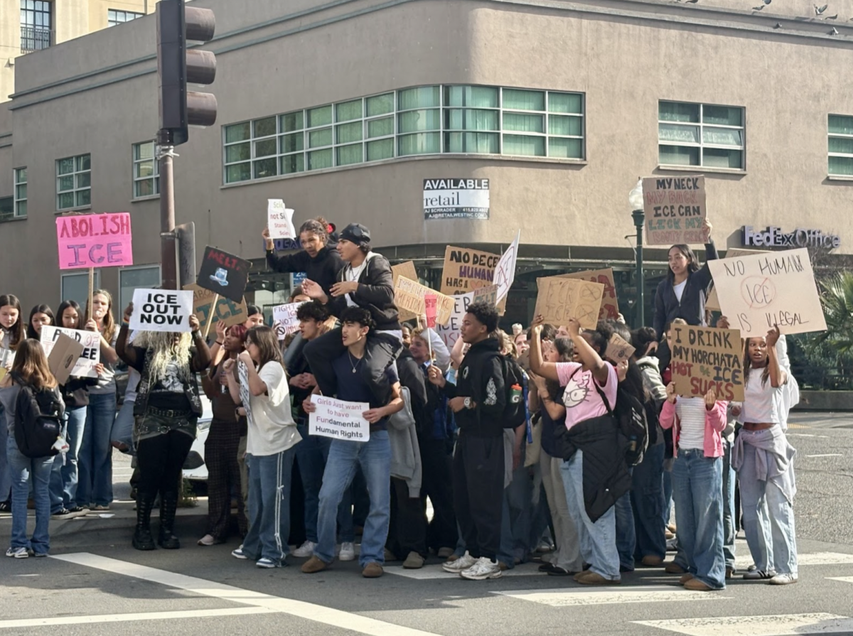 Bay Area students hold up signs in protest against ICE.