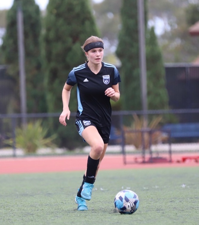 PHS girls soccer captain senior Darcy McKee dribbles the ball down the field preparing to kick while playing for her club team.
