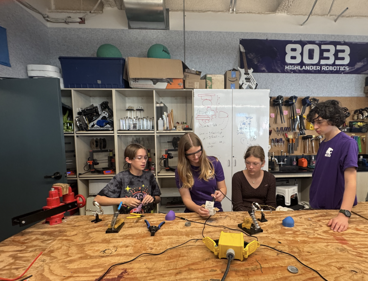 Robotics team members showing kids how to make the toys.